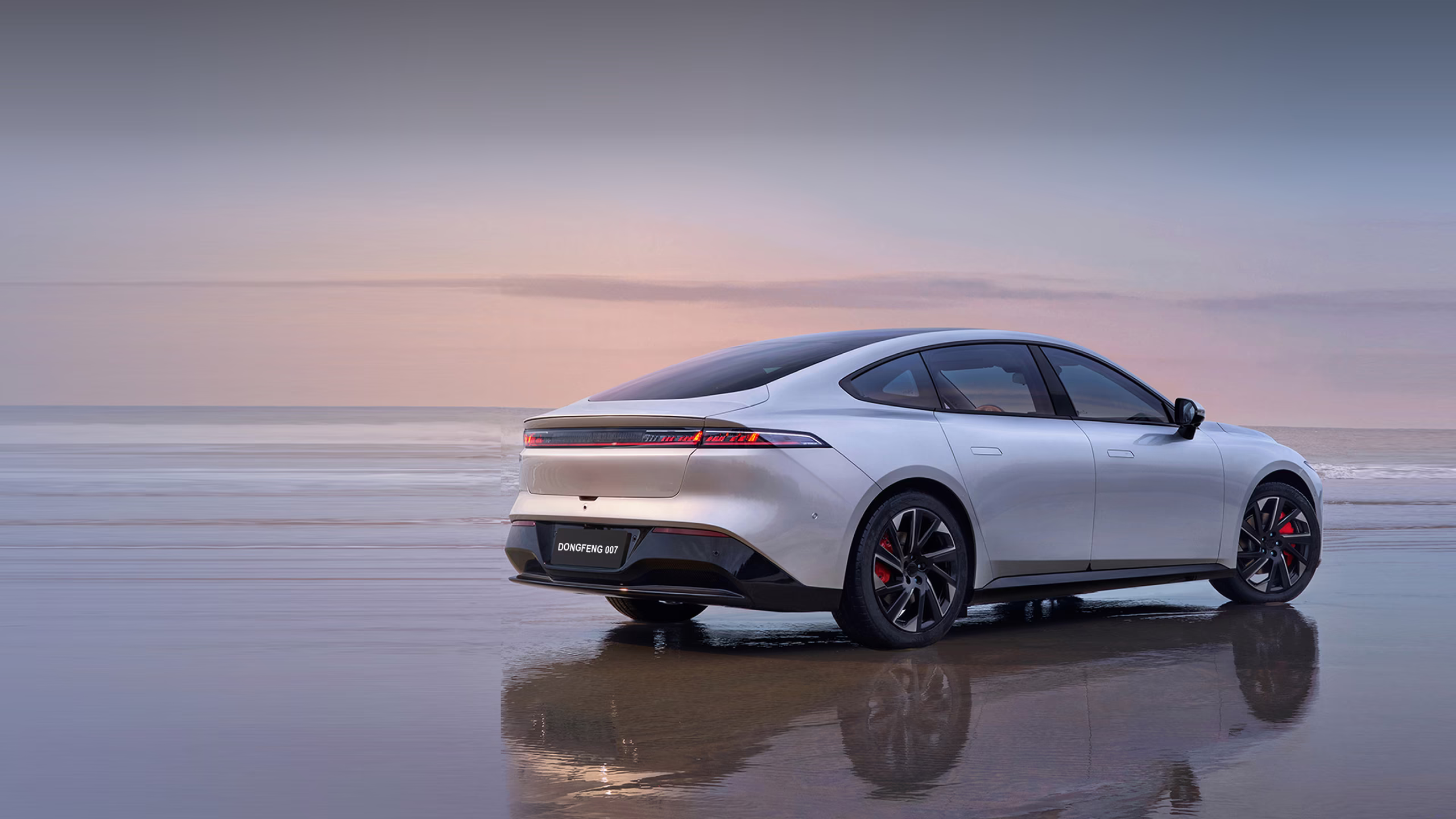 Dongfeng 007 sedan reflected on a wet beach at dusk