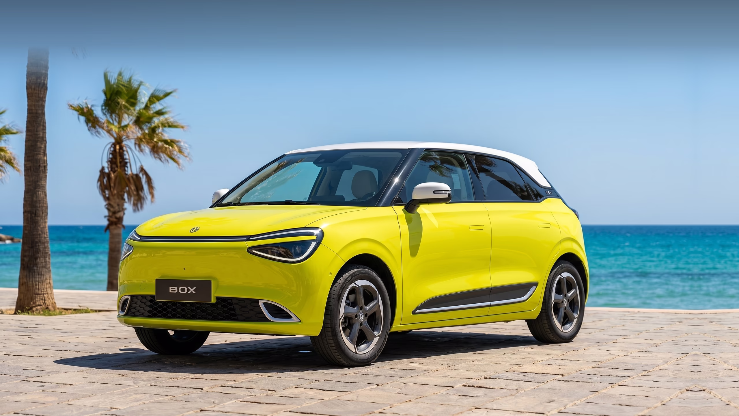 Yellow Dongfeng Box parked on a seaside promenade with palm trees